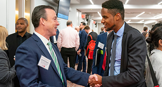 image of a student shaking a man's hand